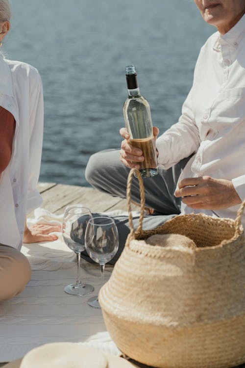 Man in White Long Sleeves Shirt Holding a Wine Bottle