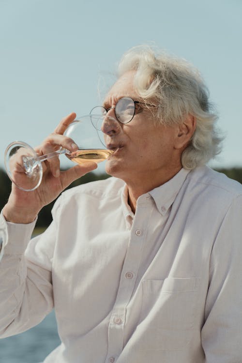 Mann Im Weißen Knopf Oben Hemd, Das Vom Klaren Trinkglas Trinkt