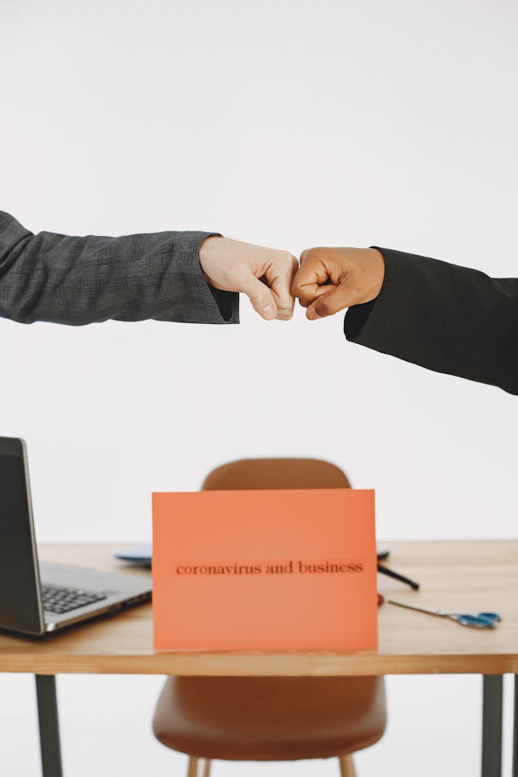 Fist Bump Over Coronavirus And Business Sign