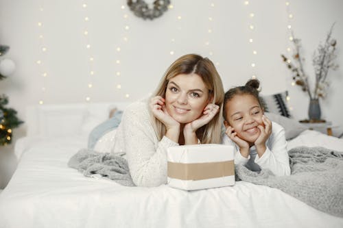 Free Mother and Daughter Lying on the Bed Stock Photo