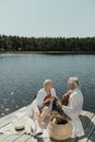 Man and Woman Sitting on White Wooden Dock