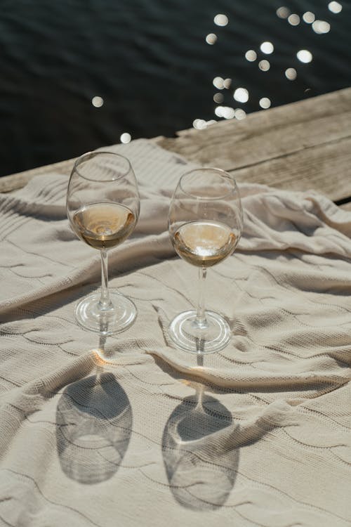 白いテキスタイルの透明なワイングラス
