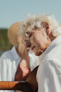 老夫妇坐在湖边，拿着吉他享受宁静的时刻