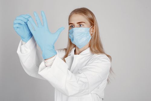 Free Female healthcare worker in protective gear preparing for a medical procedure. Stock Photo