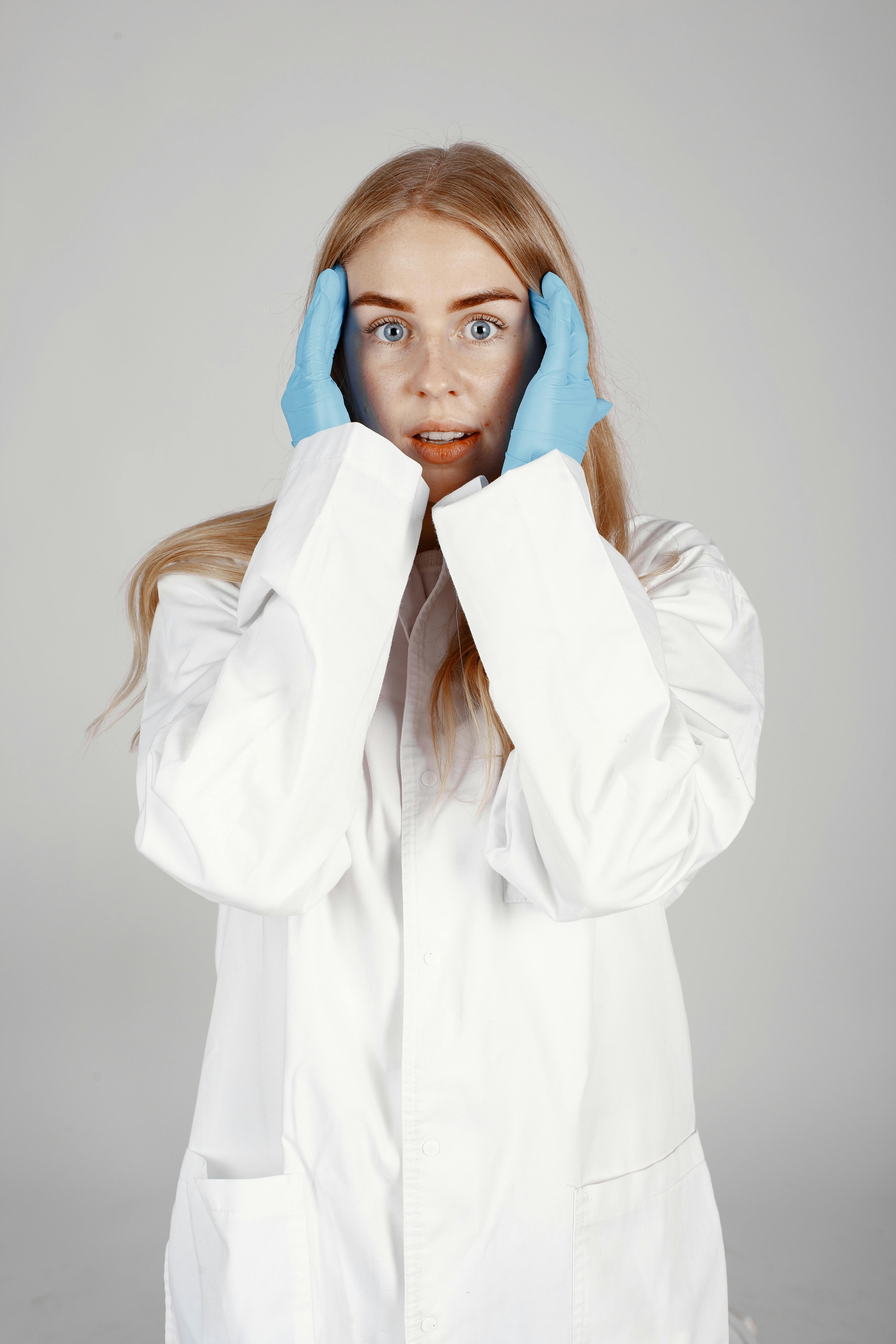 Woman in White Coat Covering Her Face With White Textile