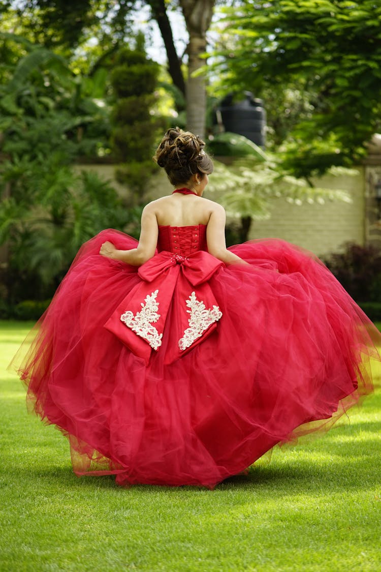 A Woman In Red Dress Running On A Grassy Field