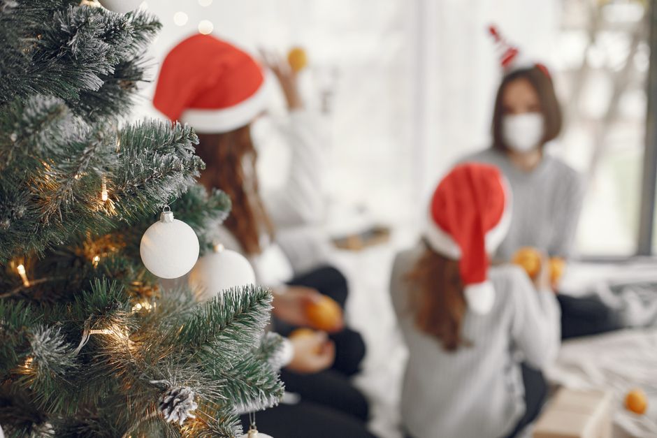 how to care for engraved gifts - A family enjoying Christmas together, wearing Santa hats indoors by a decorated tree.