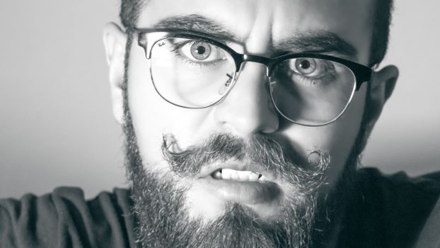 一个戴眼镜的男人，表情严肃，特写镜头为单色