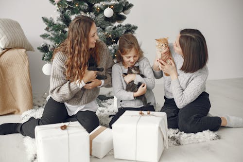 Mother with Children with Kittens near Christmas Tree