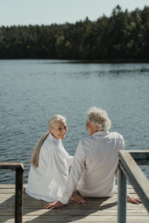 Free An Elderly Couple Sitting on a Wooden Dock Stock Photo