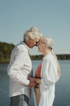 一对老夫妇在风景如画的湖边共度温馨时刻，这象征着爱与陪伴