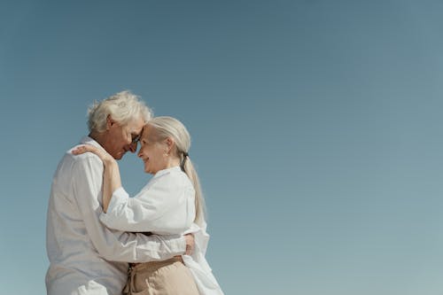 Мужчина и женщина целуются под голубым небом