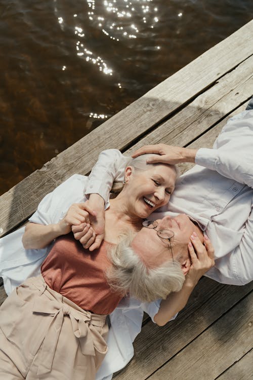 Free An Elderly Couple Lying on a Wooden Dock Stock Photo