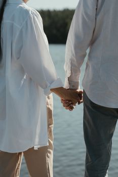 一对老年夫妇手牵着手，在湖边享受着宁静的时刻