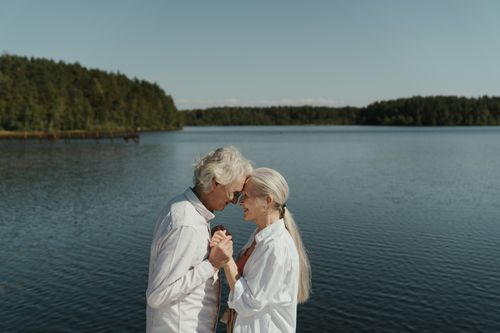 Free Senior couple in love sharing a tender moment by a tranquil lakeside. Stock Photo