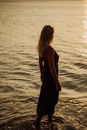 Woman in Black Spaghetti Strap Dress Standing on Seashore