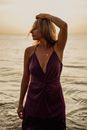 Woman in Purple Spaghetti Strap Dress Standing on Sea Shore
