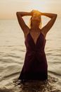 Woman in Purple Spaghetti Strap Dress Standing on Beach