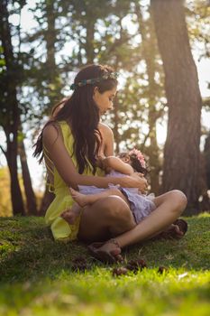 阳光明媚的森林里，一位母亲正深情地母乳喂养她的孩子