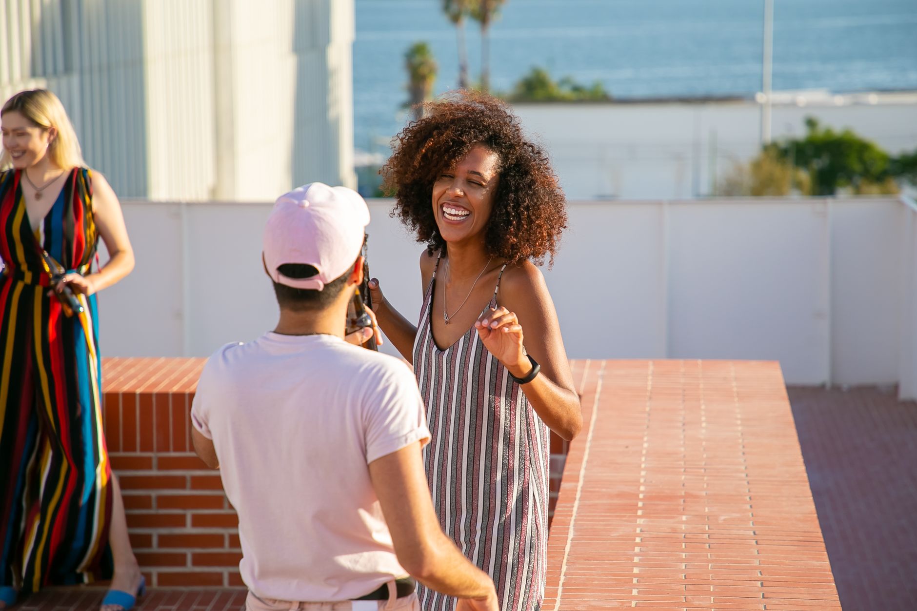 Delighted diverse friends having party on sunny rooftop