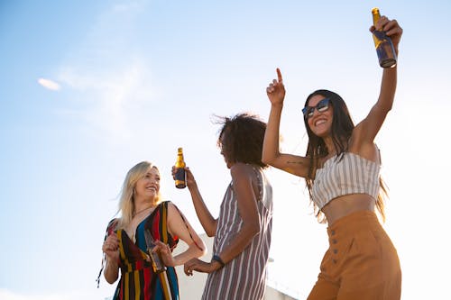 Amici Felici Che Bevono E Ballano Sulla Terrazza Soleggiata