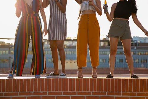 Безликие разнообразные женщины пьют пиво во время вечеринки под открытым небом на крыше