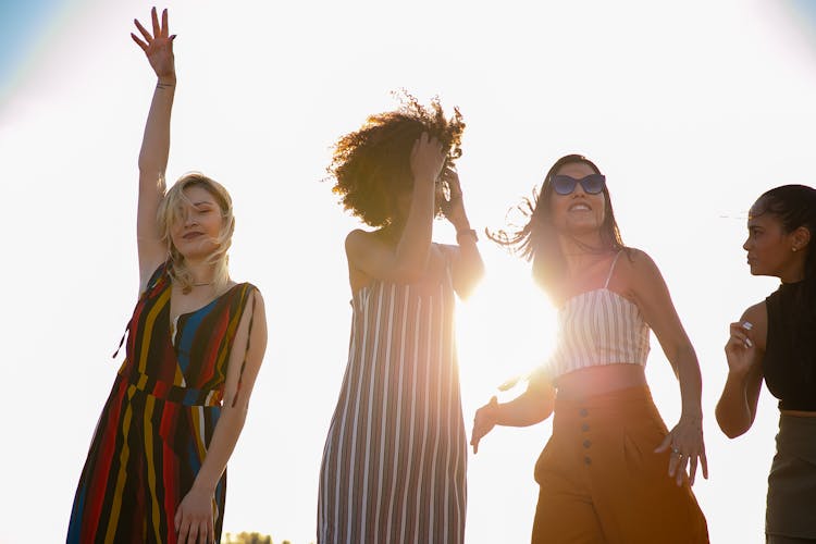 Joyful Young Multiracial Girlfriends Dancing Together During Party On Sunny Day