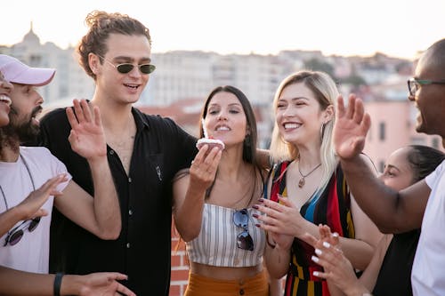 Free Happy diverse friends congratulating young ethnic woman during birthday party on rooftop Stock Photo