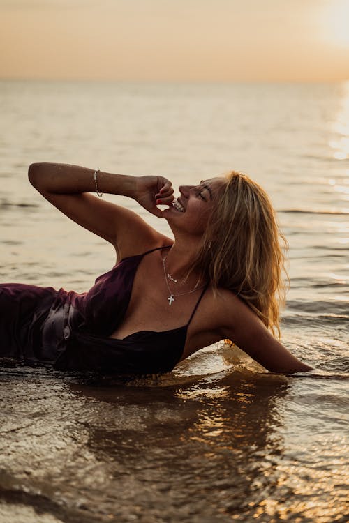 Smiling Woman Wearing Sexy Dress Lying on Water