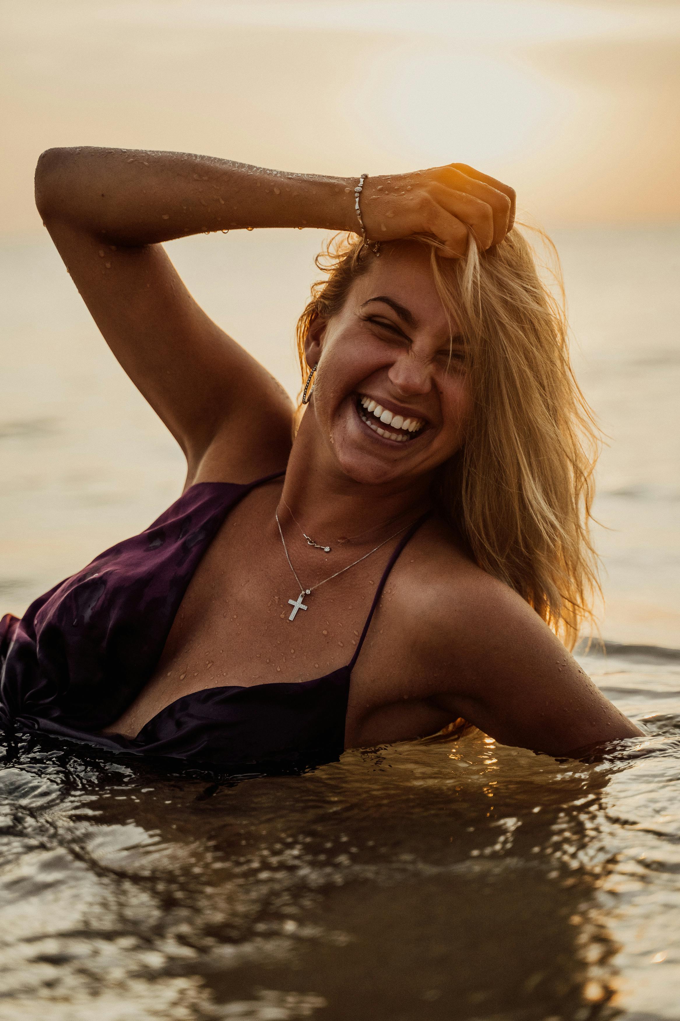 woman lying in the seashore laughing