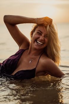 女人在海里微笑着游泳，享受日落，营造出欢乐无忧无虑的氛围