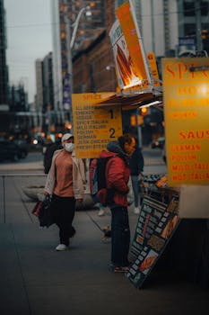 A bustling street food stand in downtown Toronto during dusk, showcasing a vibrant urban scene.