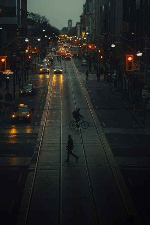 Person Riding a Bicycle Crossing on the Road during Night Time