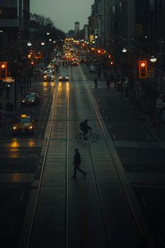多伦多夜晚的街头景象变幻莫测，车流、行人和骑行者交织其中