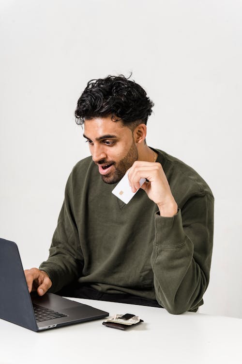 Man In Green Long Sleeve Shirt Holding White Card