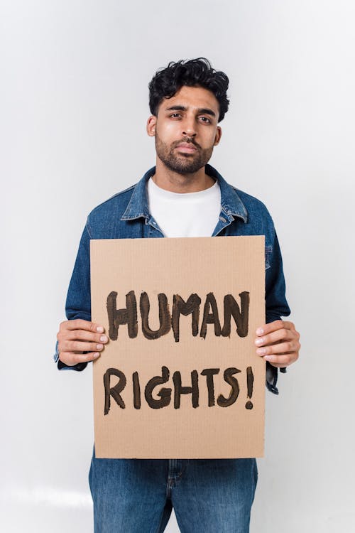Free Man In Blue And White Long Sleeve Shirt Holding Human Rights Text Stock Photo