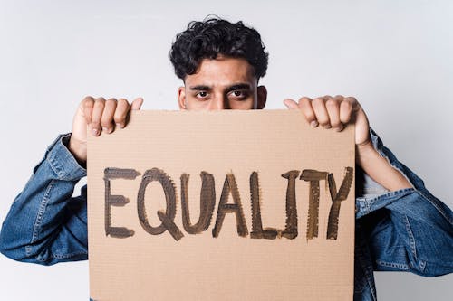Free Man Holding Cardboard With Equality Text Stock Photo