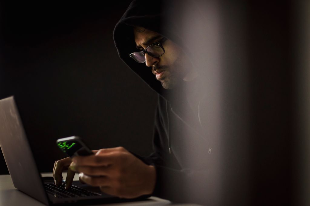 Sviluppatore al lavoro in una stanza buia, scenario tipico degli attacchi alla catena di fornitura del software open source
