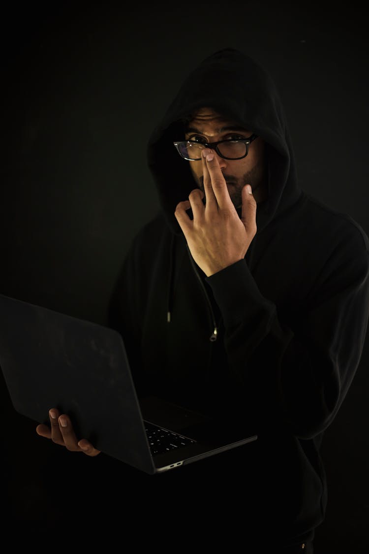 Male Computer Geek In Eyeglasses With Laptop In Darkness