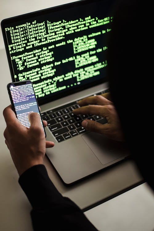 Hacker mit Laptop und Smartphone