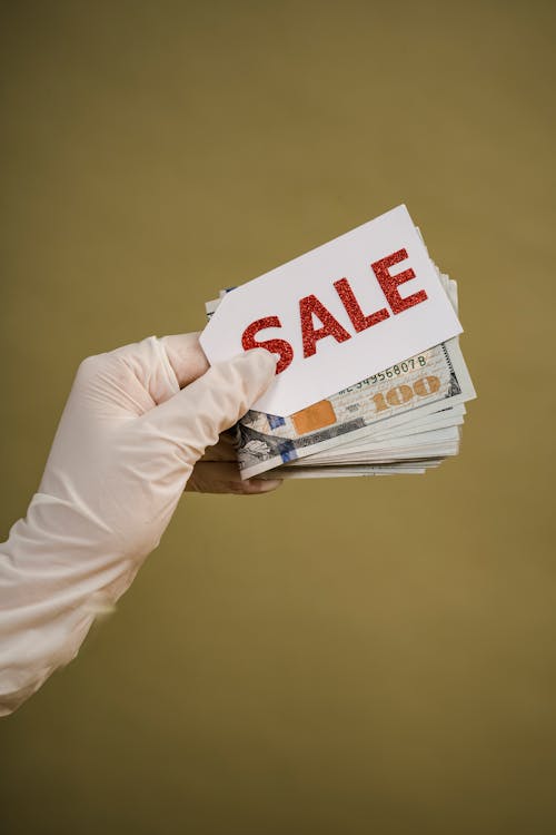 Person Holding Cash Money And Sale Tag