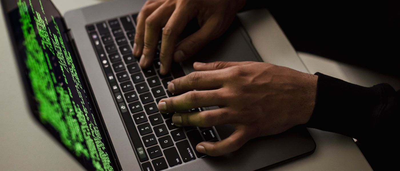 A small business owner looking at a laptop with a padlock icon, symbolizing robust endpoint protection for small business.