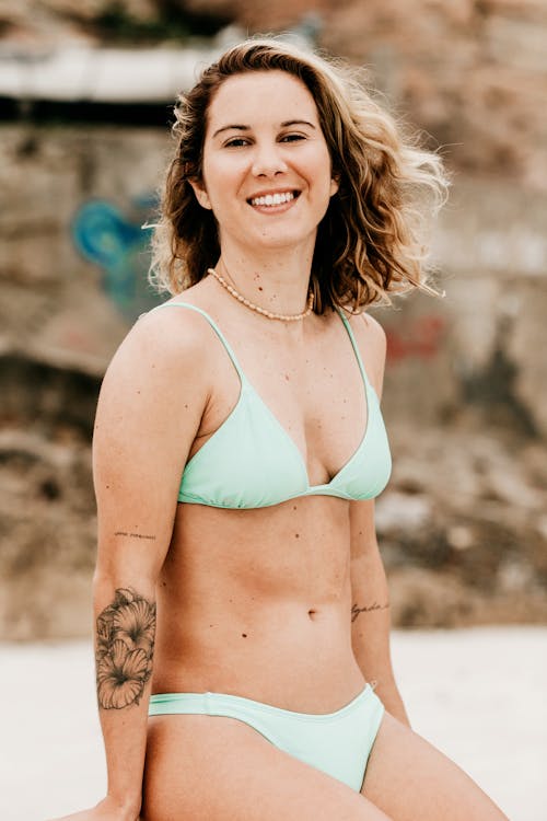 Cheerful traveler in swimwear on coast in summer