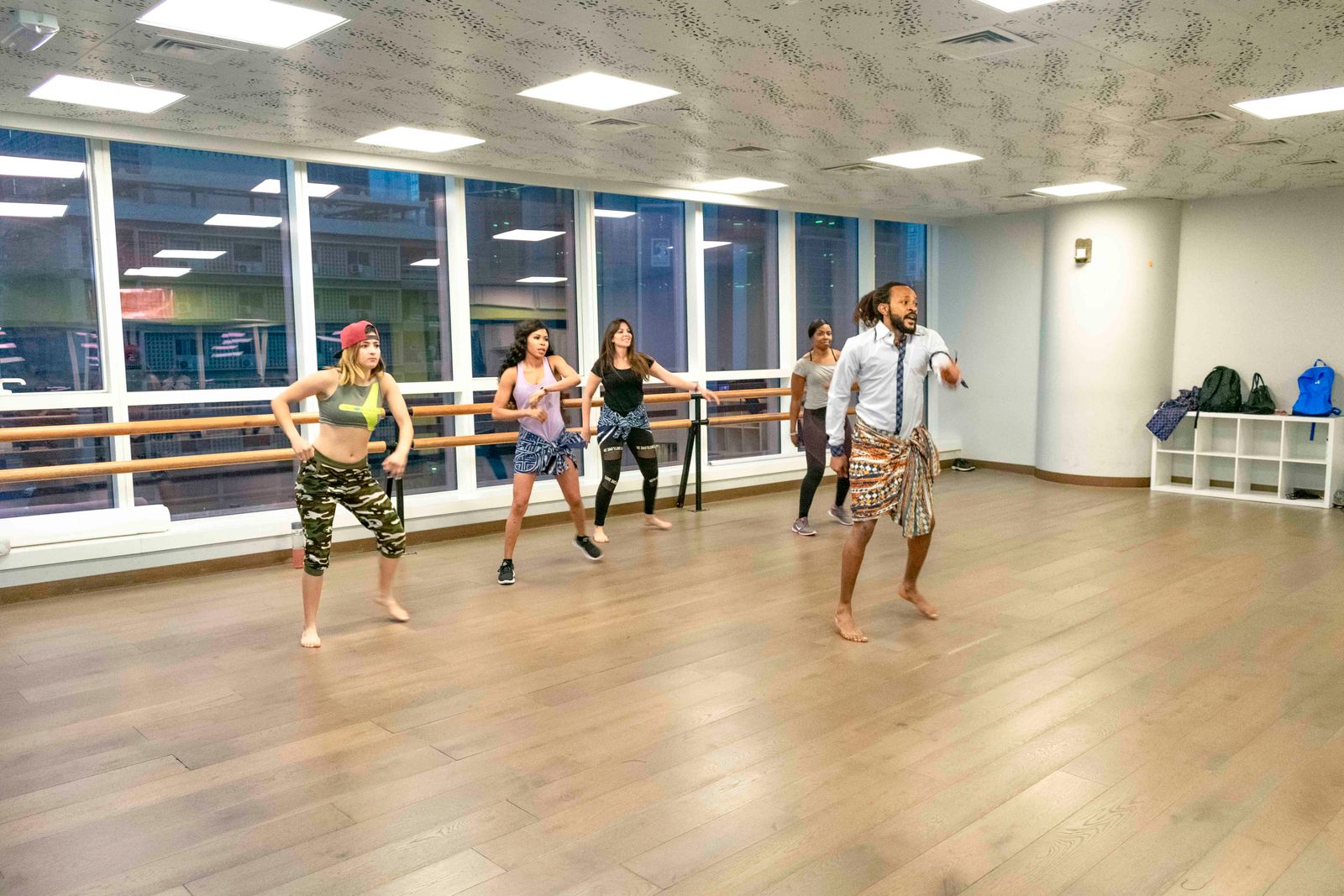 Instructor guiding a cardio dance fitness class through choreography