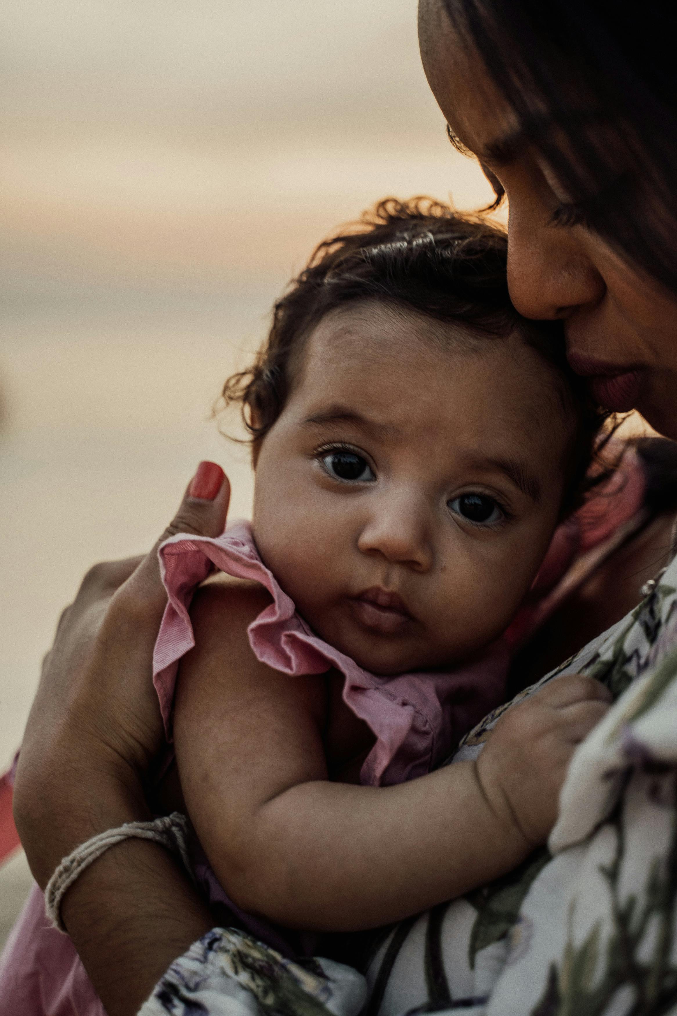 Mother Carrying a Baby · Free Stock Photo