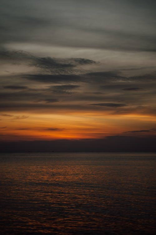 Specchio D'acqua Sotto Il Cielo Nuvoloso Durante Il Tramonto