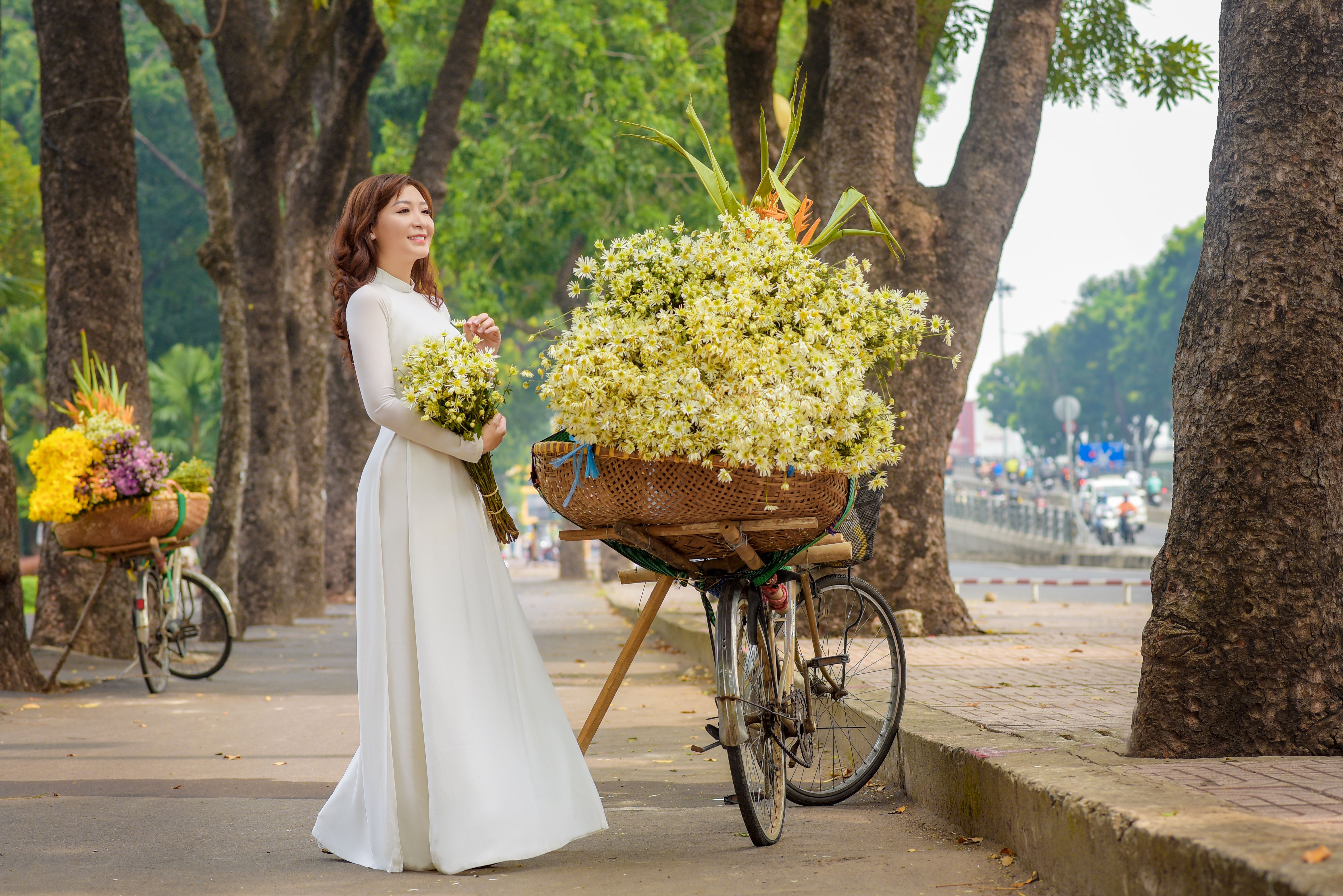 A Woman in a White Dress Holding Bouquet of Flowers · Free Stock Photo