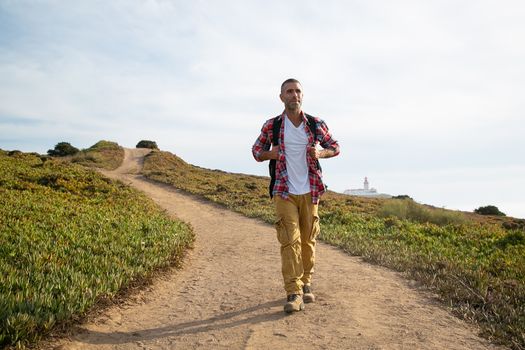 一名男子在葡萄牙风景优美的小路上徒步旅行，享受户外冒险与自然风光