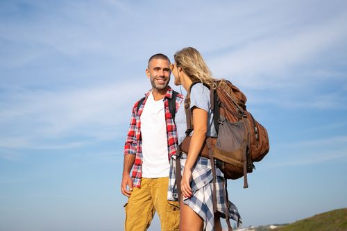 Free Smiling couple in outdoor adventure gear enjoying a hiking trip in Portugal under a clear blue sky. Stock Photo
