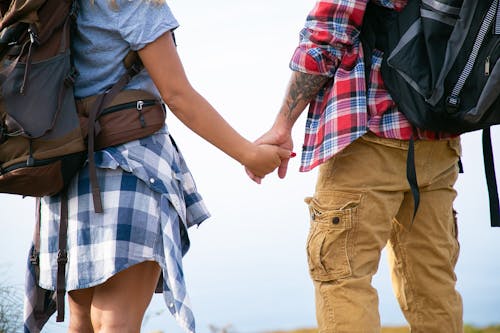 Couple with Backpacks Holding Hands 